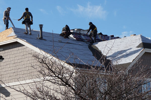 roofing crew works on new roof installation Advanced Exteriors Denver